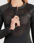a woman unzipping the front zipper of her ventilated black body suit base layer for women from Pando