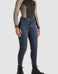 woman wearing Black and grey moto bodysuit with Pando logo and blue jeans