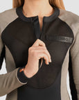 a woman unzipping front zipper of her Black and grey moto bodysuit with Pando logo