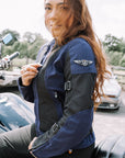 Red hair woman zipping up a Blue and black women motorcycle mesh jacket from MotoGirl
