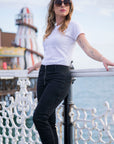 a young woman wearing white t-shirt and black moto jeans