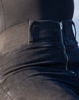 a close up of the waist line of a woman wearing black high waisted jeans with front zipper