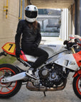 Person sitting on a Yamaha motorcycle wearing a helmet in an outdoor setting.