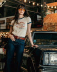 young dark haired woman standing by a retro car and wearing REAL BABES RIDE THEIR OWN retro style t-shirt