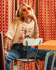 a woman wearing off white/creame colour t-shirt with retro motive that says No bullshit