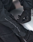 woman's hand wearing black summer motorcycle gloves zipping the sleeve of a motorcycle jacket