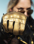 woman's fist wearing black Eudoxie mc glove with golden flames