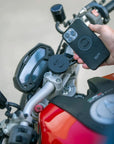A phone being mounted with the SPC mounts on a red motorcycle