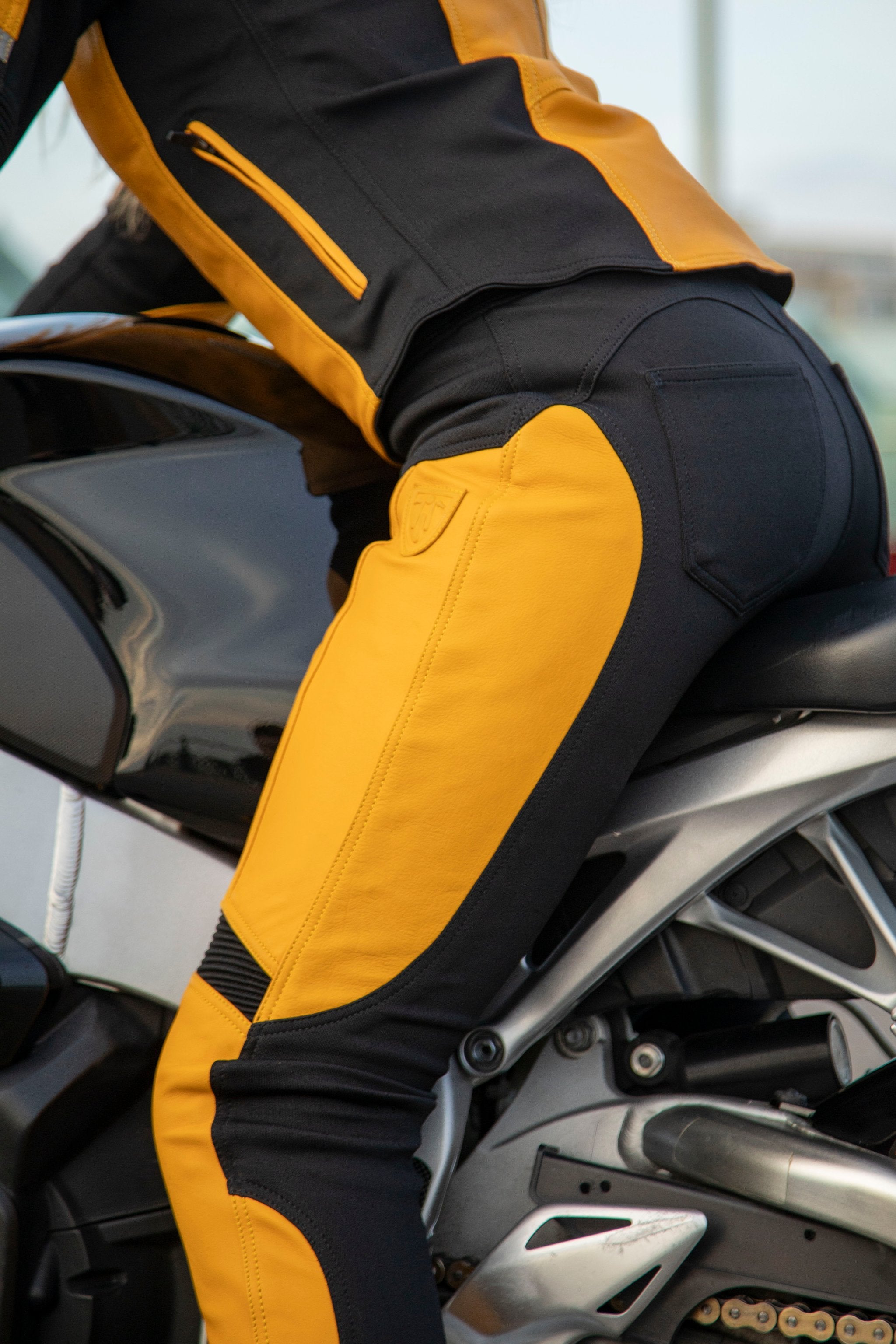 Woman sitting on motorcycle wearing Yellow Fiona Motorcycle Trousers from Moto Girl