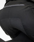 Woman's bottom wearing black textile motorcycle pants with non-slide patch  