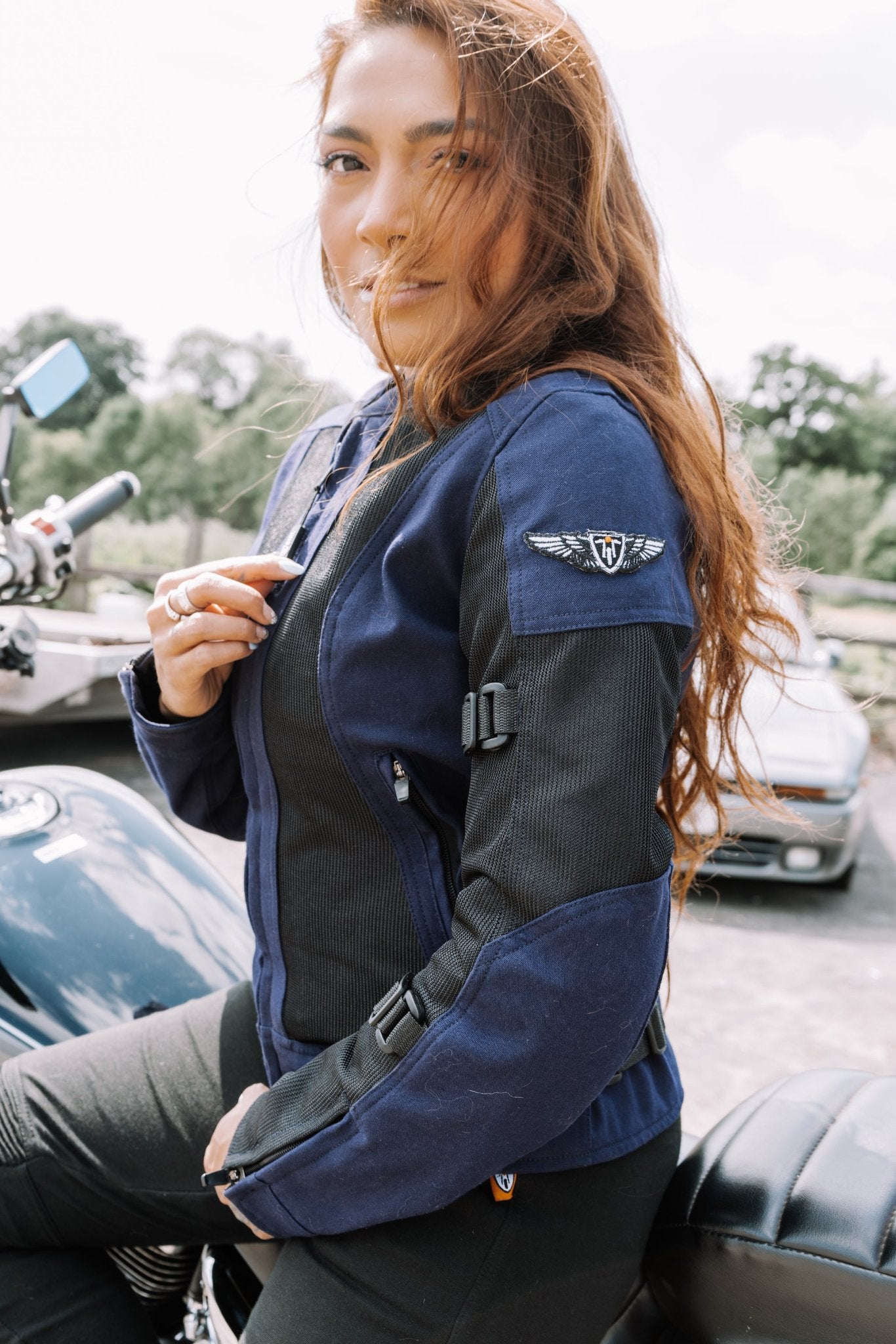 Red hair woman zipping up a Blue and black women motorcycle mesh jacket from MotoGirl 