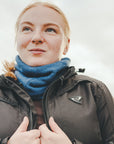 Close-up of a light red-haired woman wearing a blue knitted neck warmer from Moto Girl.