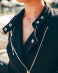 Person wearing a black leather jacket with a blurred background
