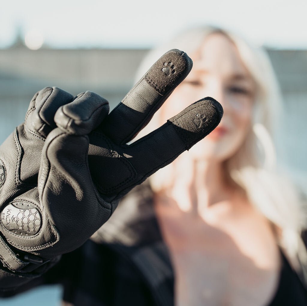 blond woman wearing the Nandi winter gloves from MotoGirl showing her index finger and middle finger with paw detail