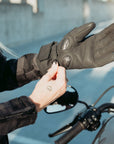 Woman standing outside wearing the Nandi gloves from Motogirl while adjusting the velcro closure on the wrist.