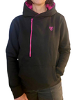 A woman wearing black Moto Girl helmet hoodie with pink details and front zipper 