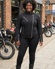 Woman in black outfit standing in front of a motorcycle cafe.