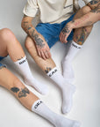 Woman's and man's legs wearing white socks with "break" and "gear"