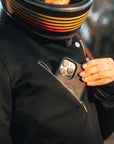 woman pitting her phone in a pocket of a Black retro style woman's motorcycle jacket with silver zip details