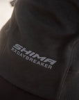 Close-up of a black hoodie with a gray embroidered logo reading 'SHIMA 7DAYBREAKER' on the back, worn by a person.