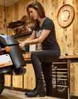 Woman mechanic in the garage wearing women's black leather motorcycle shoes 