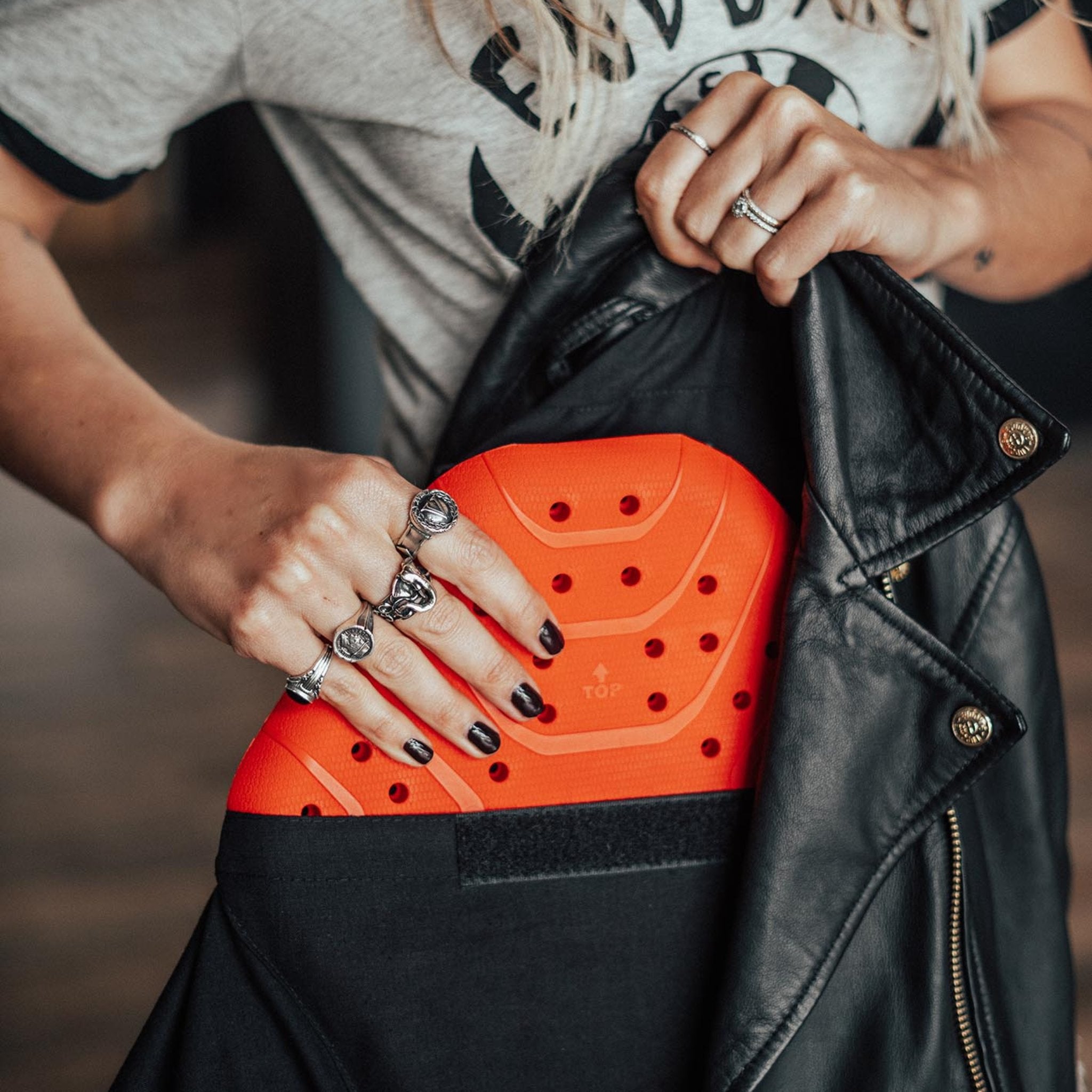 A woman taking out the back protector from the motorcycle jacket