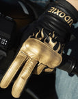 Woman's hand on a throttle wearing black Eudoxie mc glove with golden flames 