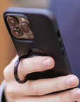 A man holding his phone using the ring holder 