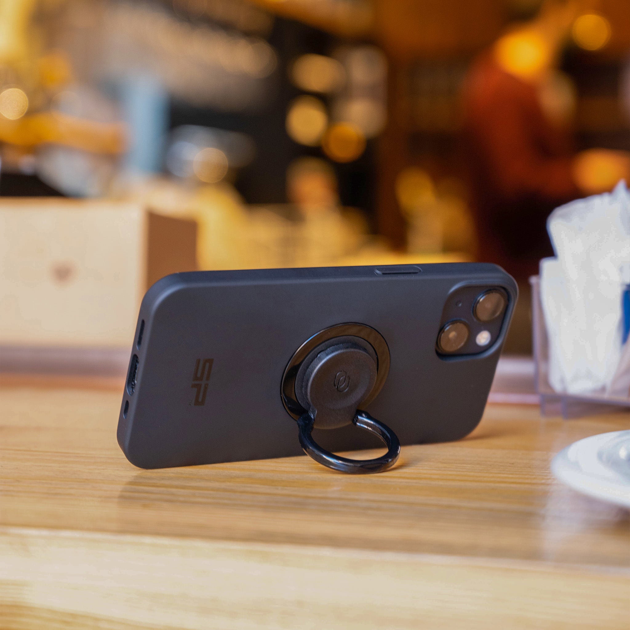 A phone on the table leaning on the ring holder 